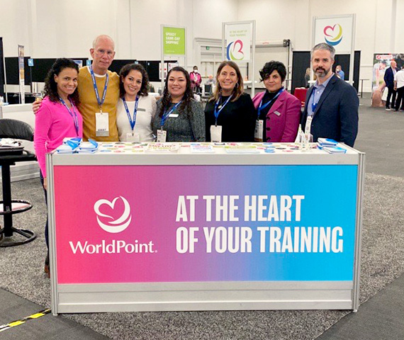 Group of WorldPoint employees at conference exhibition booth