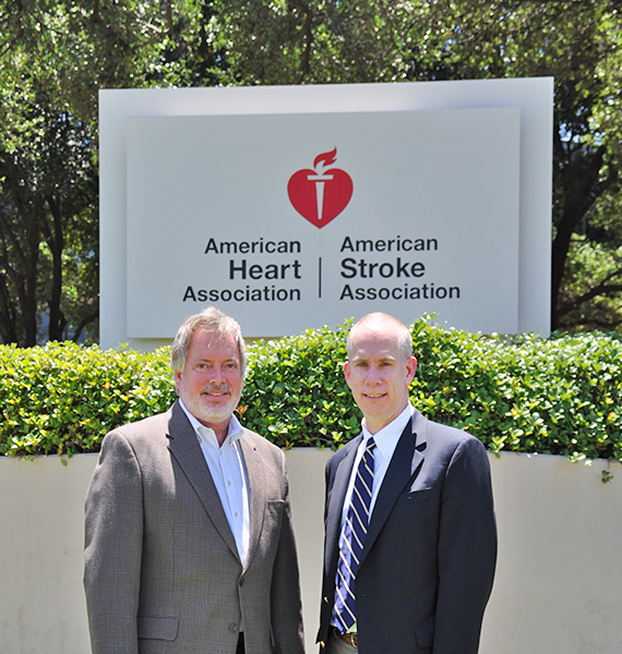John Meiners & John Amato in front of American Heart Association logo sign